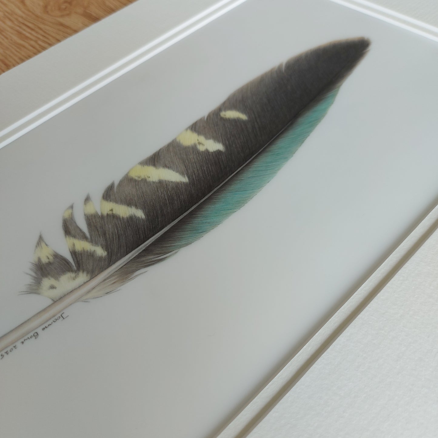 Angled view of the original kea feather artwork, showing surface texture and depth